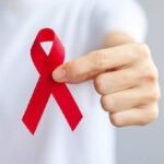 man in white t-shirt holding a red ribbon