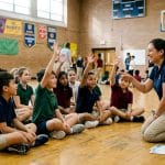 Students participating at school assembly with presenter